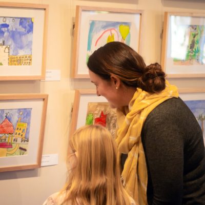 Mother and daughter looking at her artwork of Market Square in Burra at the opening of Heart and Soul of the Country.